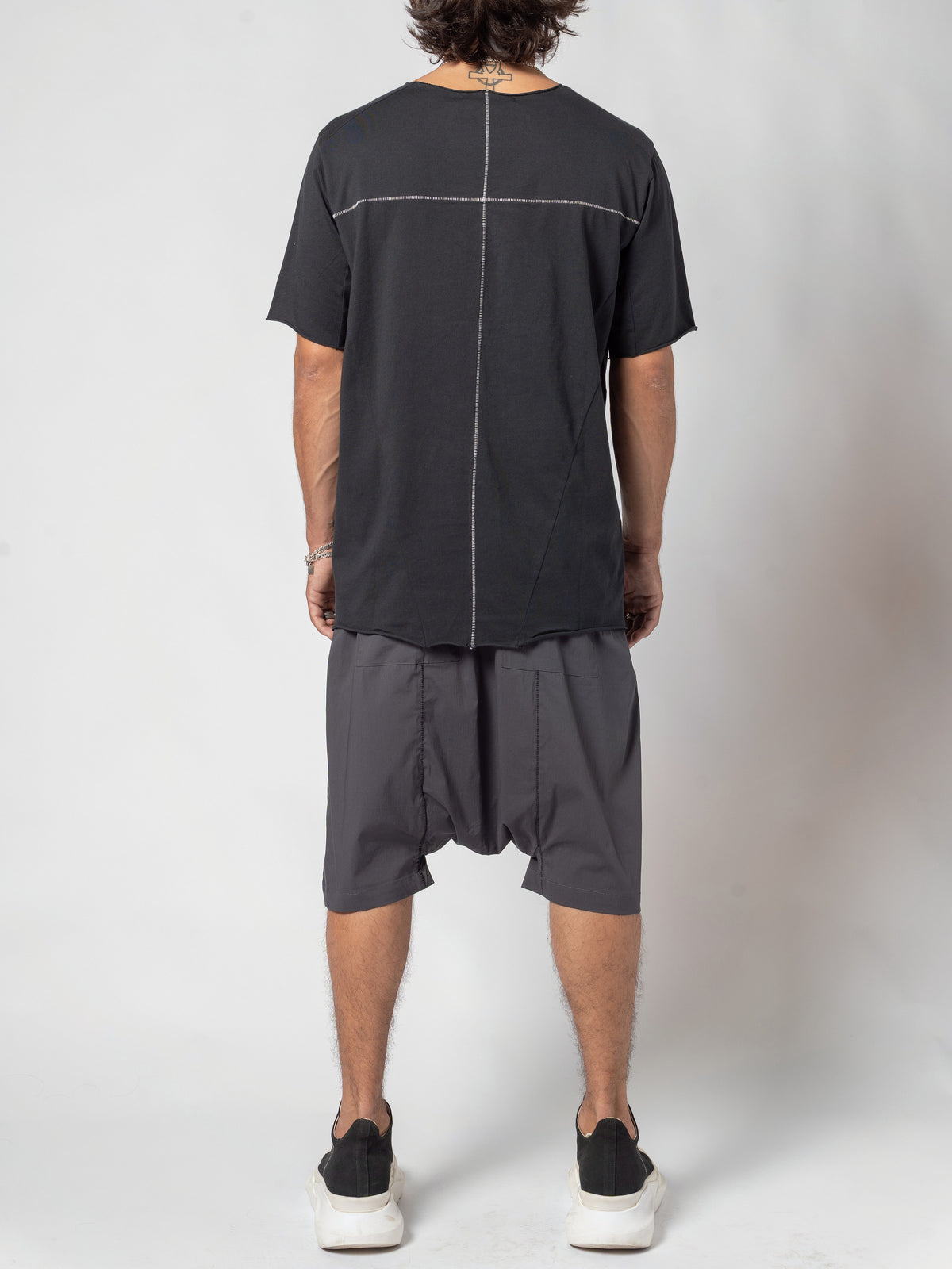 AITO Scar Stitch Cotton T-Shirt in Black — full-length back view, standing square, the contrast seams reading the length of the back