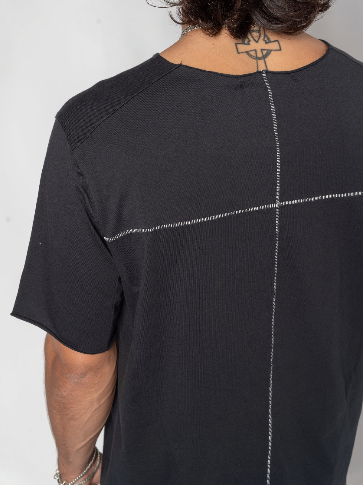 AITO Scar Stitch Cotton T-Shirt in Black — close-up of the upper back where the horizontal and vertical contrast seams cross