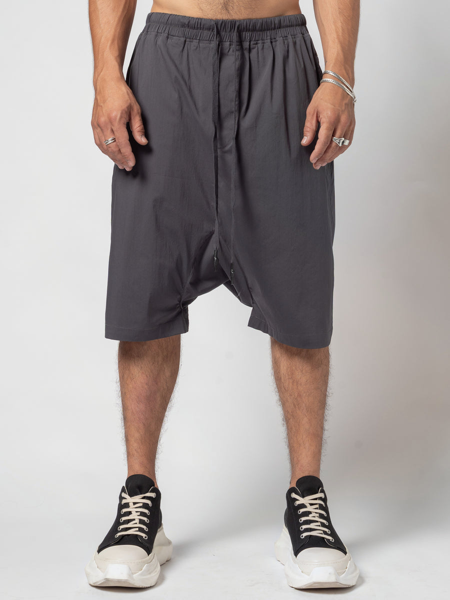 AITO Drop-Crotch Cotton Shorts in Dark Grey — full-length front view from the waistband down to the trainers, both hands at his sides