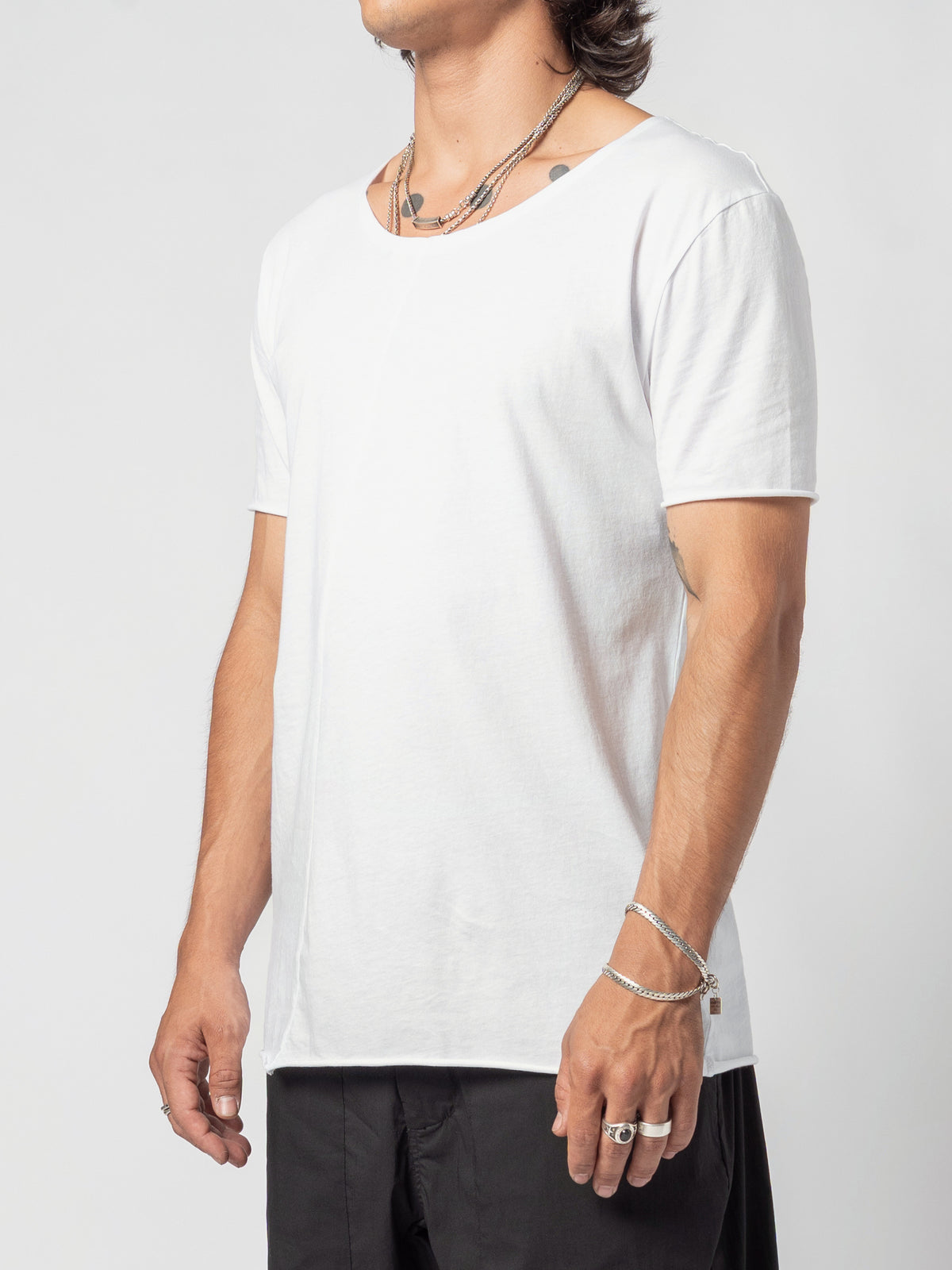 AITO Scoop Neck Cotton T-Shirt in White — three-quarter turned back towards the lens, the full neckline and the hem at the hip