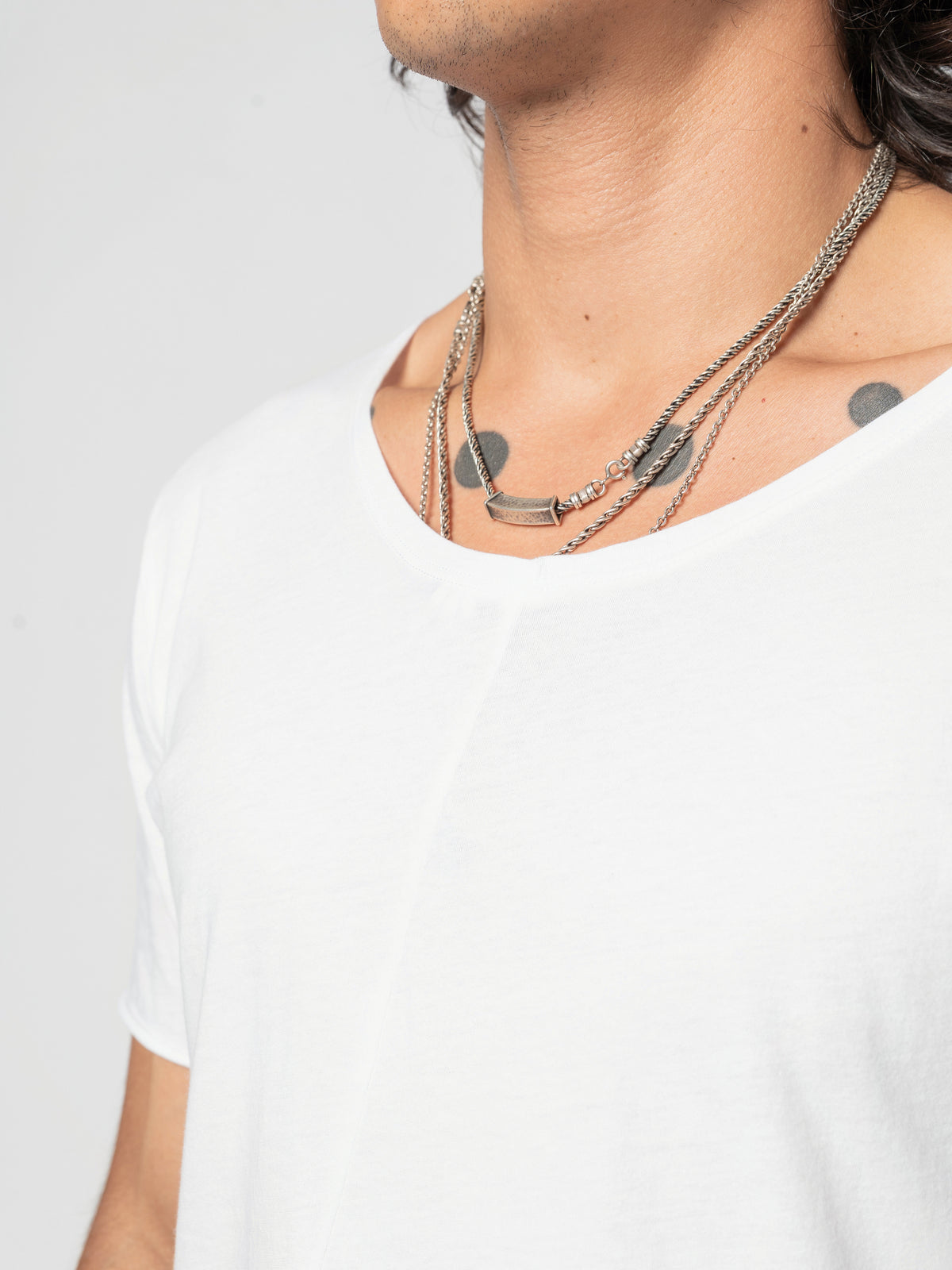 AITO Scoop Neck Cotton T-Shirt in White — tight close-up of the neckline at the collarbone, the shoulder turned towards the camera