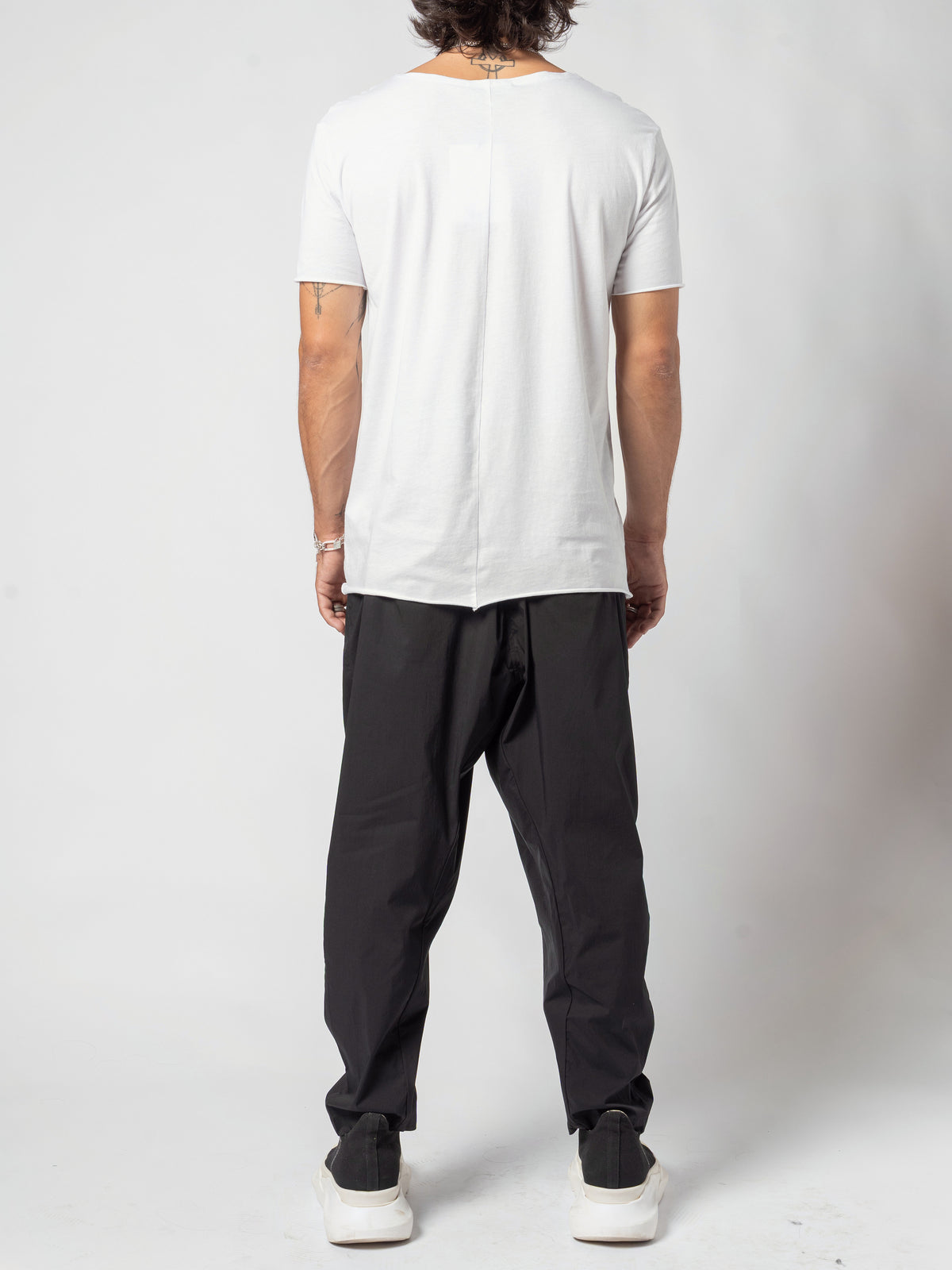 AITO Scoop Neck Cotton T-Shirt in White — full-length back view, standing straight with the shirt over black trousers
