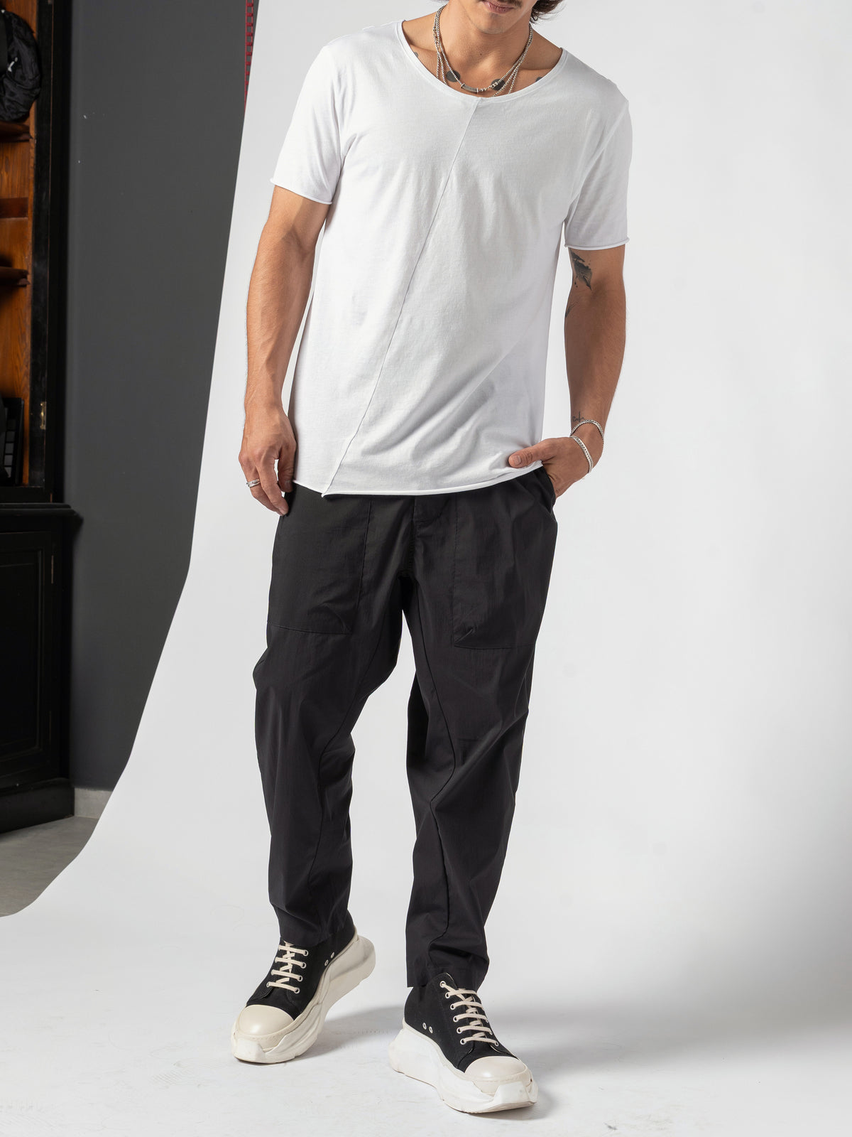 AITO Scoop Neck Cotton T-Shirt in White — full-length front, feet apart, both hands in the trouser pockets
