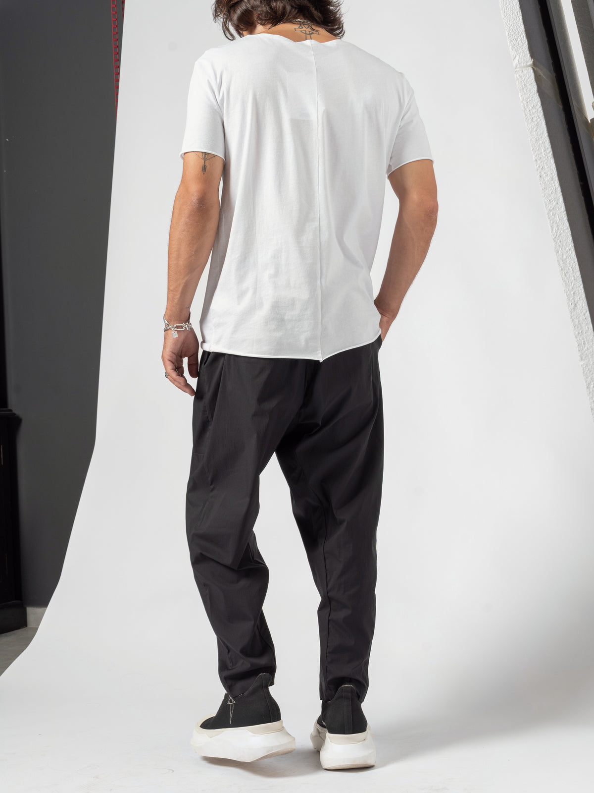 AITO Scoop Neck Cotton T-Shirt in White — full-length back view with both hands in the trouser pockets