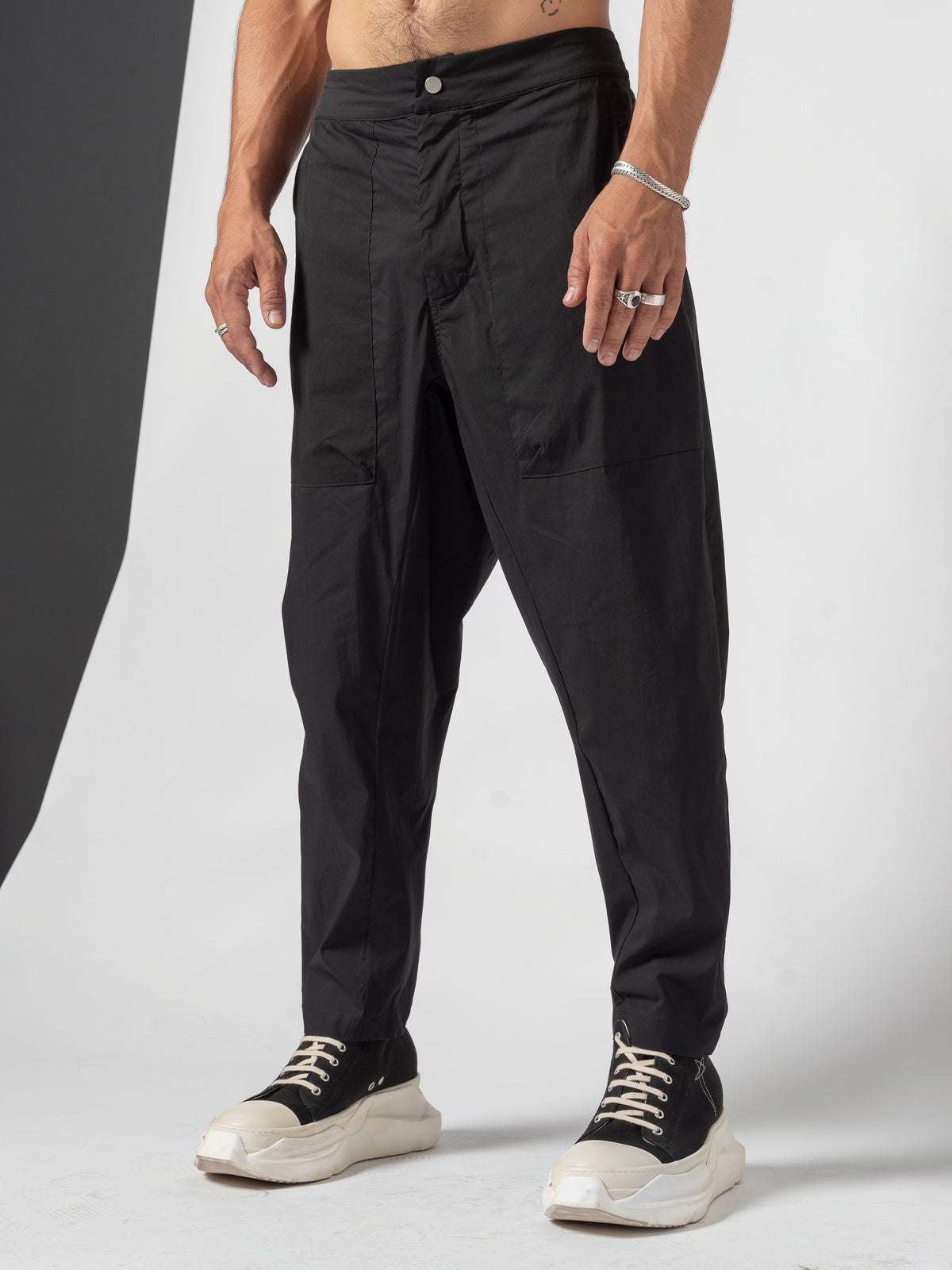 AITO Pleated Drop-Crotch Pants in Black — full-length front view in a wide stance, arms hanging clear of the pleated front