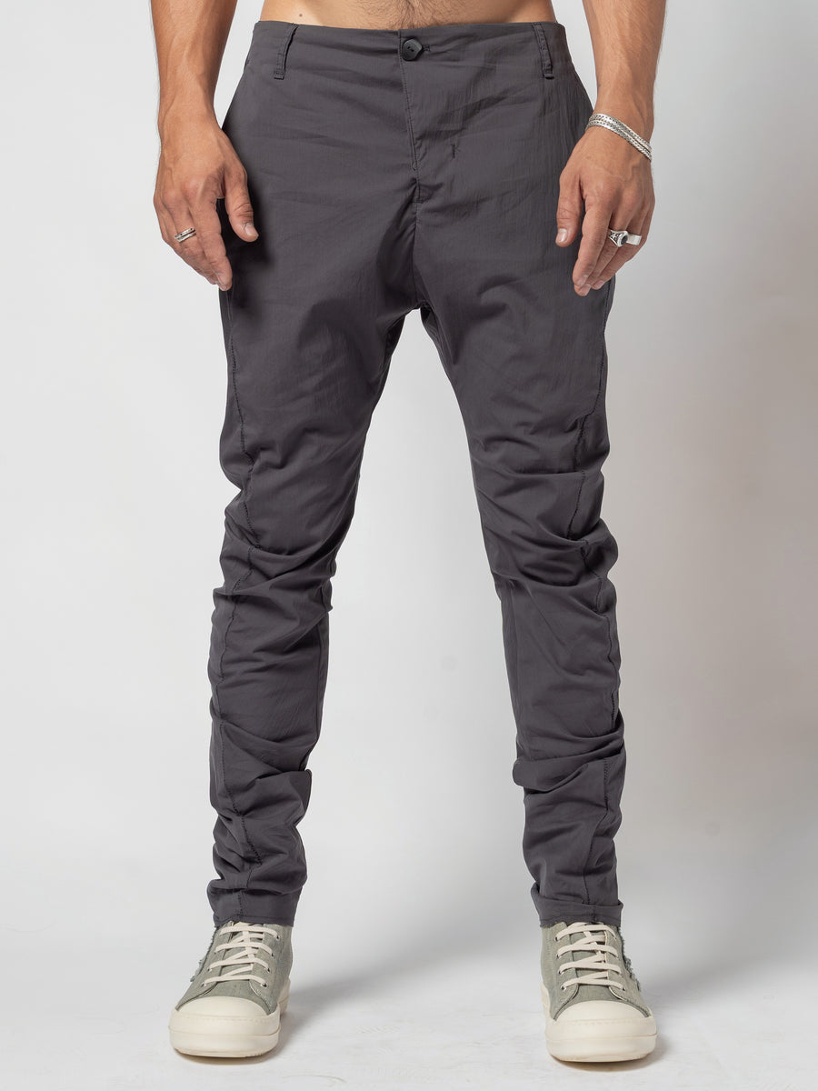 AITO Stacked Hem Slim Pants in Dark Grey — front view with the arms held away from the body and both feet planted, the hem breaking low on the shoe