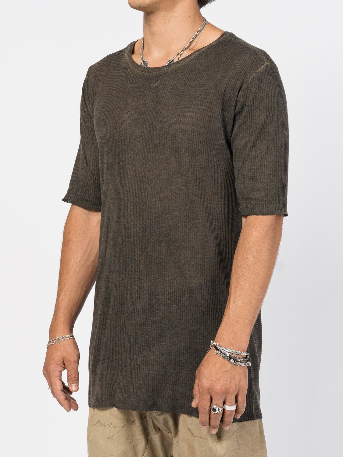 AITO Ribbed Cotton T-Shirt in Charcoal — three-quarter side view on the model, showing the close drape and raw-cut sleeve edge.