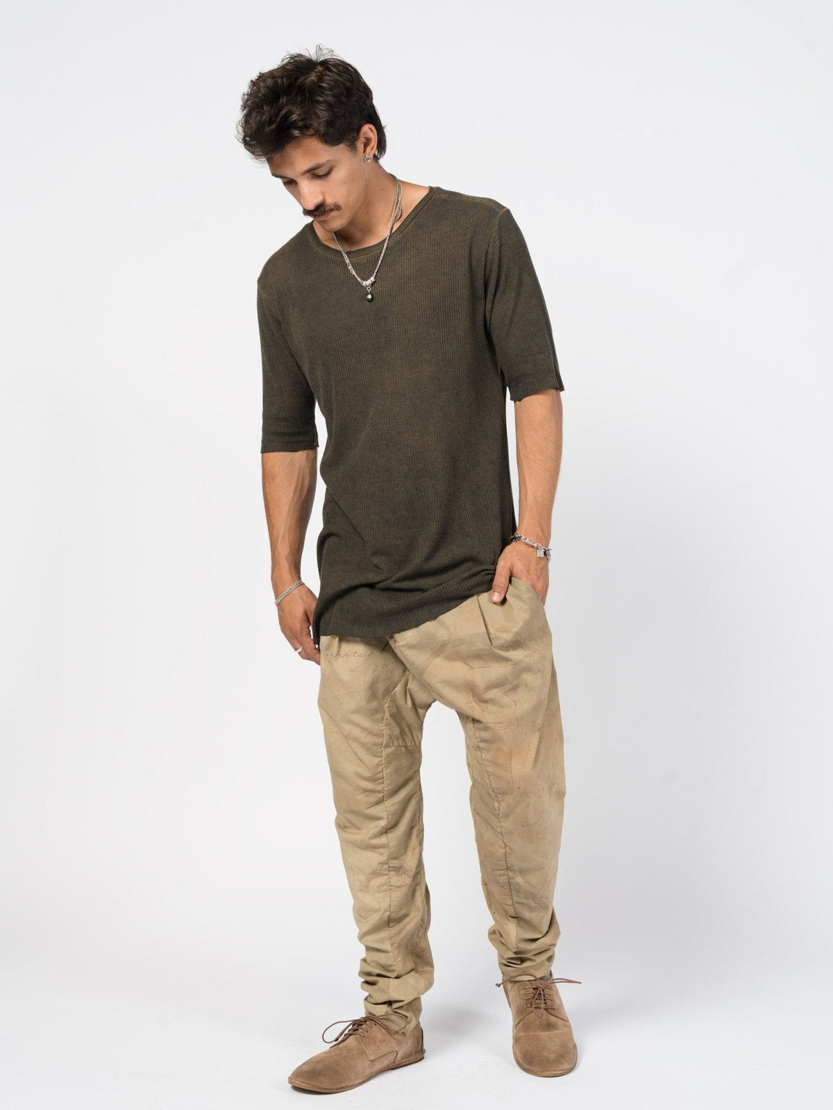 AITO Ribbed Cotton T-Shirt in Militare — full-length front view on model showing the long, straight silhouette and raw-cut hem styled with tapered trousers.