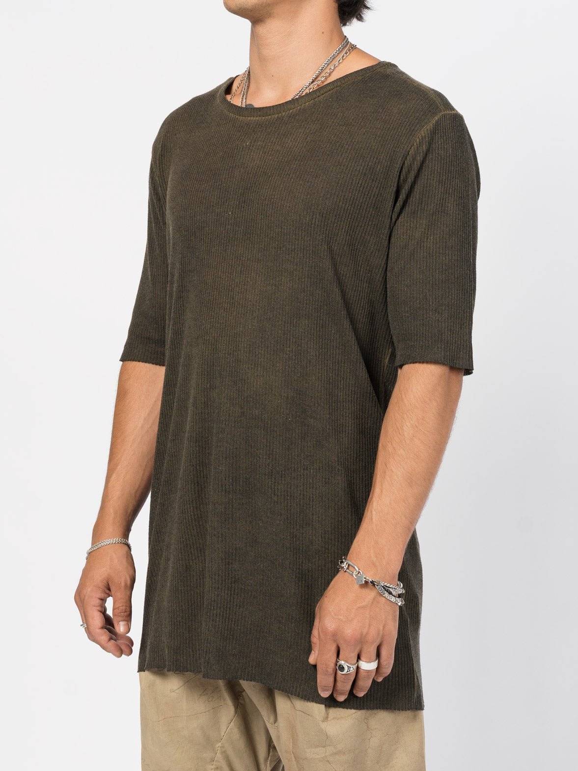 AITO Ribbed Cotton T-Shirt in Militare — three-quarter side view on model showing the straight drape, side seam and raw sleeve edge.