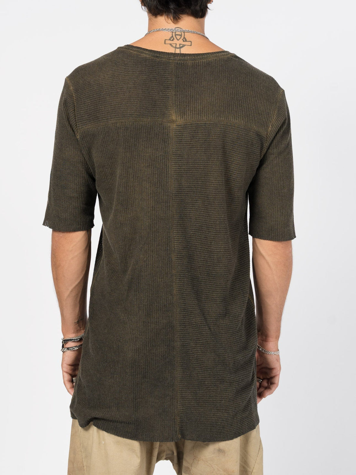 AITO Ribbed Cotton T-Shirt in Militare — back view on model showing the horizontal yoke seam and vertical centre-back seam dividing the panel into opposing-rib quarters.