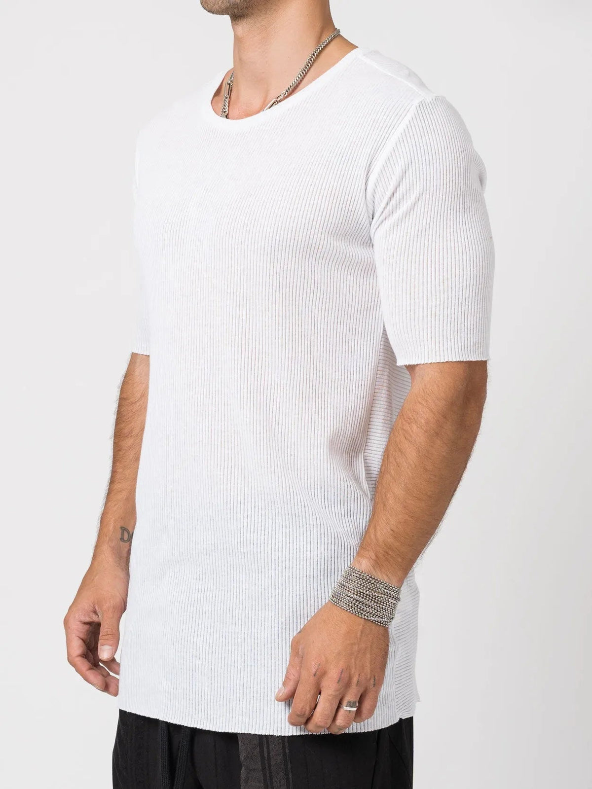 AITO Ribbed Cotton T-Shirt in White — three-quarter view showing the slim, elongated silhouette and raw curled hem